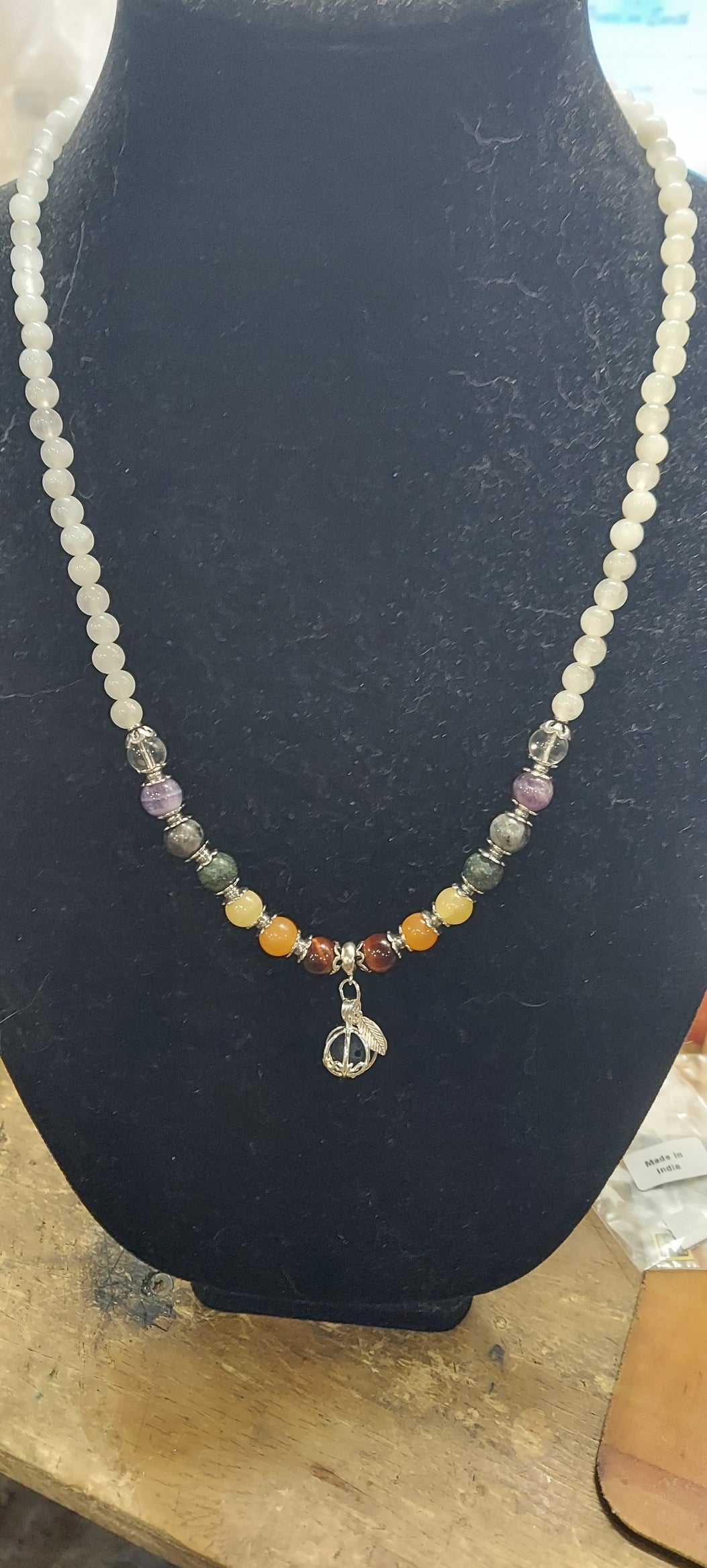 Necklace with multicolored beads on a black stand