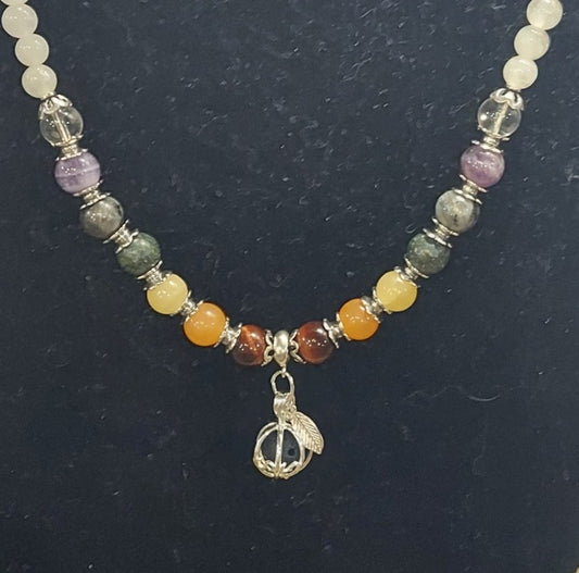 Necklace with multicolored beads and a gold pendant on a dark background
