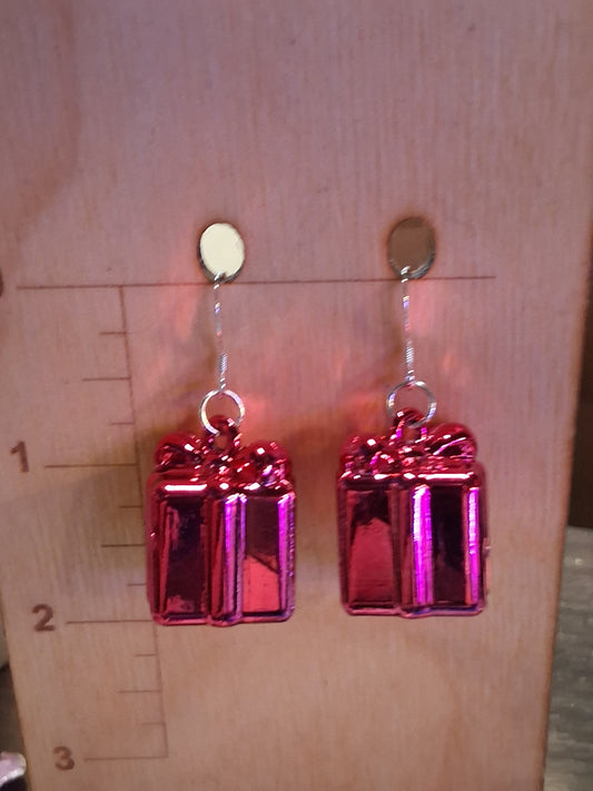 Pink rectangular present earrings on a wooden surface with a ruler for scale.